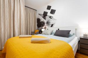 um quarto com uma cama com um cobertor amarelo em Downtown Cube Apartment em Budapeste
