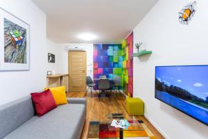 uma sala de estar com um sofá e uma televisão de ecrã grande em Downtown Cube Apartment em Budapeste