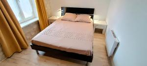 een klein bed in een kamer met een raam bij Le Cosyhome Michelais I SPA extérieur & Netflix in Saint-Michel-le-Cloucq