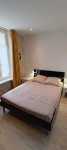 een groot bed in een slaapkamer met een raam bij Le Cosyhome Michelais I SPA extérieur & Netflix in Saint-Michel-le-Cloucq