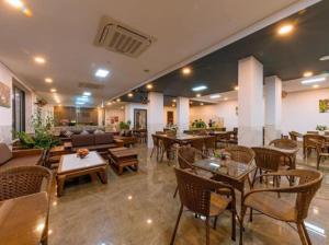 a restaurant with tables and chairs and a couch at An Bình Tân Hotel in Nha Trang