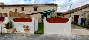 een wit hek voor een huis bij Le Cosyhome Michelais I SPA extérieur & Netflix in Saint-Michel-le-Cloucq