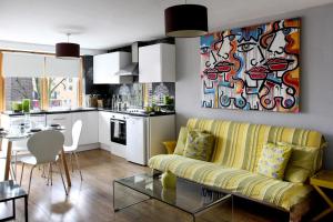ロンドンにあるAngelのリビングルーム(黄色のソファ付)、キッチンが備わります。