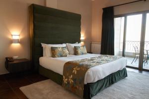 a bedroom with a large bed with a green headboard at Cherry Blossom Boutique Hotel in Bḩamdūn +51 photos
