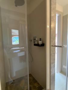 La salle de bains est pourvue d'une douche avec une porte en verre. dans l'établissement Villa Agnona Appartamento in Villa, à Borgosesia