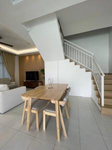 een woonkamer met een houten tafel en een trap bij Rumatepi in Melaka