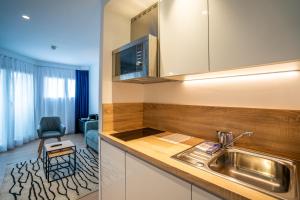 uma cozinha com um lavatório e uma sala de estar em abba Apartments Playa de Gros San Sebastián em San Sebastián