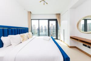 a bedroom with a large bed with a large window at BRAND-NEW 1 Bedroom with full Marina View in Dubai