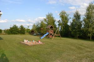 a playground in a field with a slide at Domek mamy in Tykocin