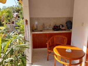 a kitchen with a wooden table and a table and chairs at OkaOki Homestay in Amed