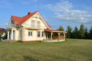 a large house with a large grass yard at Domek mamy in Tykocin