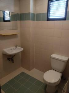 a bathroom with a toilet and a sink at Grand Residence Ngamwongwan 19 in Nonthaburi