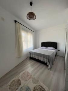 1 dormitorio con 1 cama en una habitación blanca en Kumsal Evleri & Kuzey - Bahçeli, Denize 200m, en Bozyazı