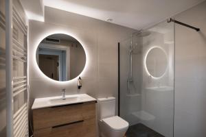 a bathroom with a toilet and a sink and a mirror at Apartamentos4U Tudela Plaza Parking Incluido in Tudela +42 photos