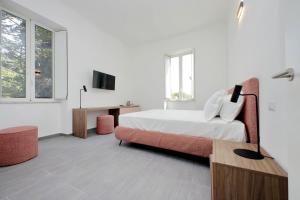 biała sypialnia z łóżkiem i telewizorem w obiekcie Youroom Monteverde - Rooms w Rzymie