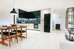 uma cozinha com uma mesa de madeira e um frigorífico preto em Menta Loft em Heraclião