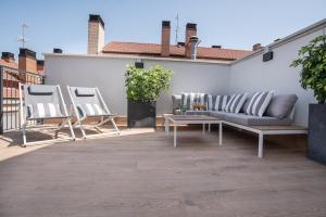 eine Terrasse mit einem Sofa und Stühlen auf dem Dach in der Unterkunft Apartamentos4U Tudela Plaza Parking Incluido in Tudela