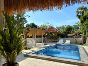 a swimming pool with chairs and a gazebo at OkaOki Homestay in Amed