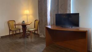 a hotel room with a television and a table with chairs at Ilsenburger Hof - NEUER BETREIBER in Ilsenburg