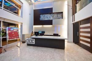 een lobby met een tv en een receptie bij Hotel The Pearl in New Delhi