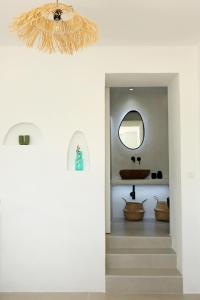 a hallway with a bathroom with a sink and a mirror at Syrolia village in Kinion