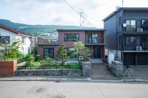 a brick house with a fence in front of it at The Villa Moiwa in Sapporo