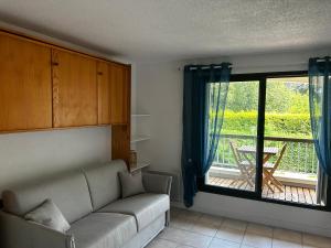 a living room with a couch and a large window at Joli Studio in Grand-Village-Plage +3 photos
