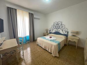 a bedroom with a bed with a blue head board at San Raffaele Guest House in Villasimius