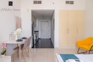 a kitchen and dining room with a table and chairs at Mira Holiday Homes - Spacious Studio with Balcony - Free Wifi in Dubai