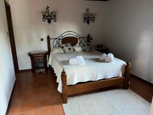 - une chambre avec un lit doté de draps et d'oreillers blancs dans l'établissement QUINTA DONA MANUELA, à Formariz