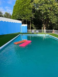 - une grande piscine avec 2 chaises rouges dans l'eau dans l'établissement QUINTA DONA MANUELA, à Formariz