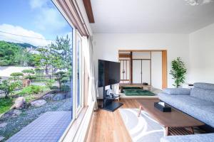 a living room with a couch and a large window at The Villa Moiwa in Sapporo