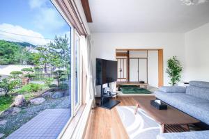 札幌市にあるThe Villa Moiwaのソファと大きな窓のあるリビングルーム