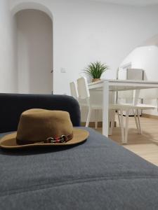 a hat sitting on a bed in a living room at Casa do Raymundo in Évora