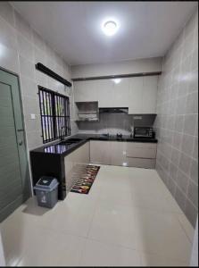 uma cozinha com paredes de azulejos brancos e um piso branco em Q Homestay @ Temerloh em Temerloh