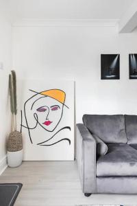 een woonkamer met een bank en een schilderij van een vrouw bij Nice 2 bedroom house in Stowmarket in Stowmarket