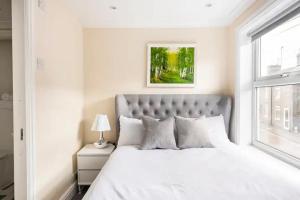 a bedroom with a large white bed with a window at Nice 2 bedroom house in Stowmarket in Stowmarket