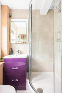 a bathroom with a purple sink and a shower at Nice 2 bedroom house in Stowmarket in Stowmarket