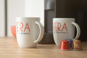 two coffee cups sitting on top of a table at Brera Serviced Apartments Singen in Singen