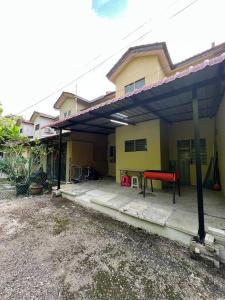 una casa con un garaje con una mesa roja. en Netflix Wifi Homestay Kak Nad Saujana Utama, en Sungai Buloh