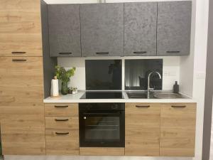 uma cozinha com armários de madeira e um forno preto em LuLu Naxos Apartment em Giardini Naxos