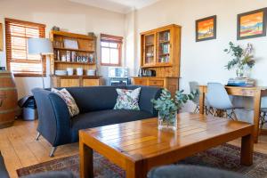ein Wohnzimmer mit einem blauen Sofa und einem Holztisch in der Unterkunft Lovane Boutique Wine Estate and Guesthouse in Stellenbosch