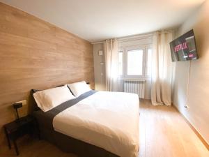 um quarto com uma cama e uma televisão na parede em ¡Más céntrico imposible! 6PAX+PK em Andorra-a-Velha