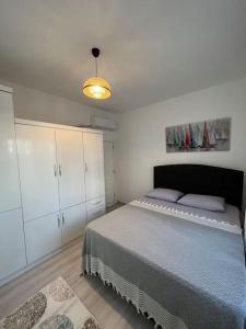 een slaapkamer met een bed en witte kasten bij Kumsal Evleri & Güney - Bahçeli, Denize 200m in Bozyazı