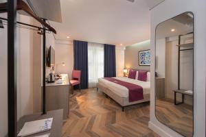 a hotel room with a bed and a mirror at The Belamy House Managed by HII in Manila