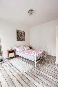 - une chambre blanche avec un lit et un tapis dans l'établissement Main Square Apartment, à Pula