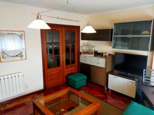 a living room with a tv and a glass table at Piso Corunna Easy Parking wifi in Arteixo