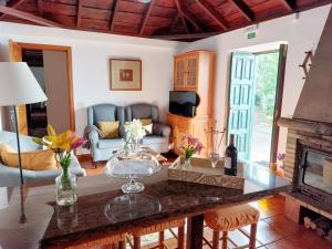 uma sala de estar com uma mesa e uma lareira em Eloína em Barlovento