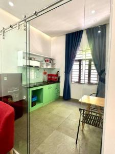 a kitchen with green cabinets and a table in a room at POOLseaview - 1A Blue Sea Apart in Da Nang
