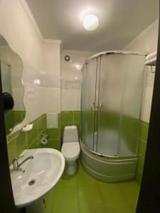 a bathroom with a sink and a shower and a toilet at AMBER Hotel & Cafe in Bohorodchany +61 photos
